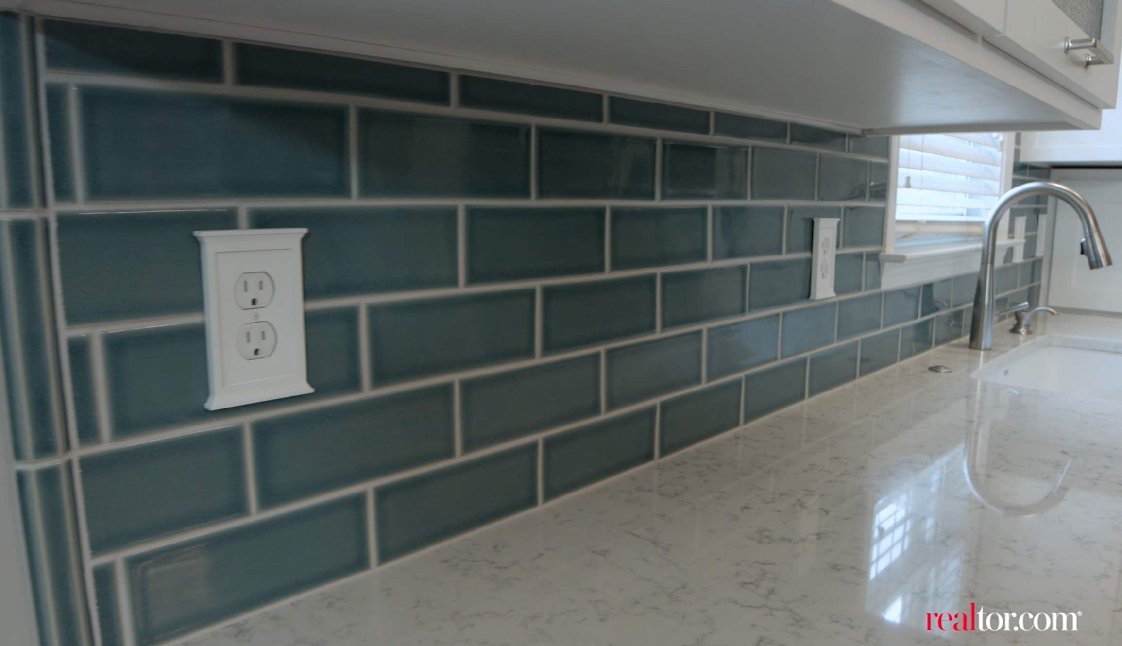 This teal backsplash provides a necessary pop of color. 